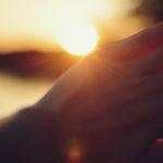 Hand shielding eyes from the setting sun