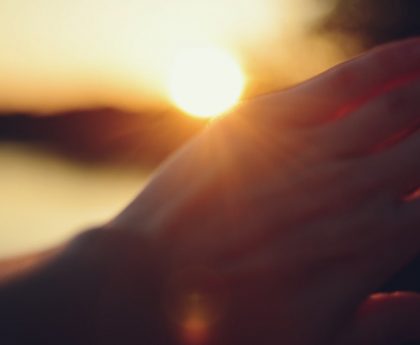 Hand shielding eyes from the setting sun