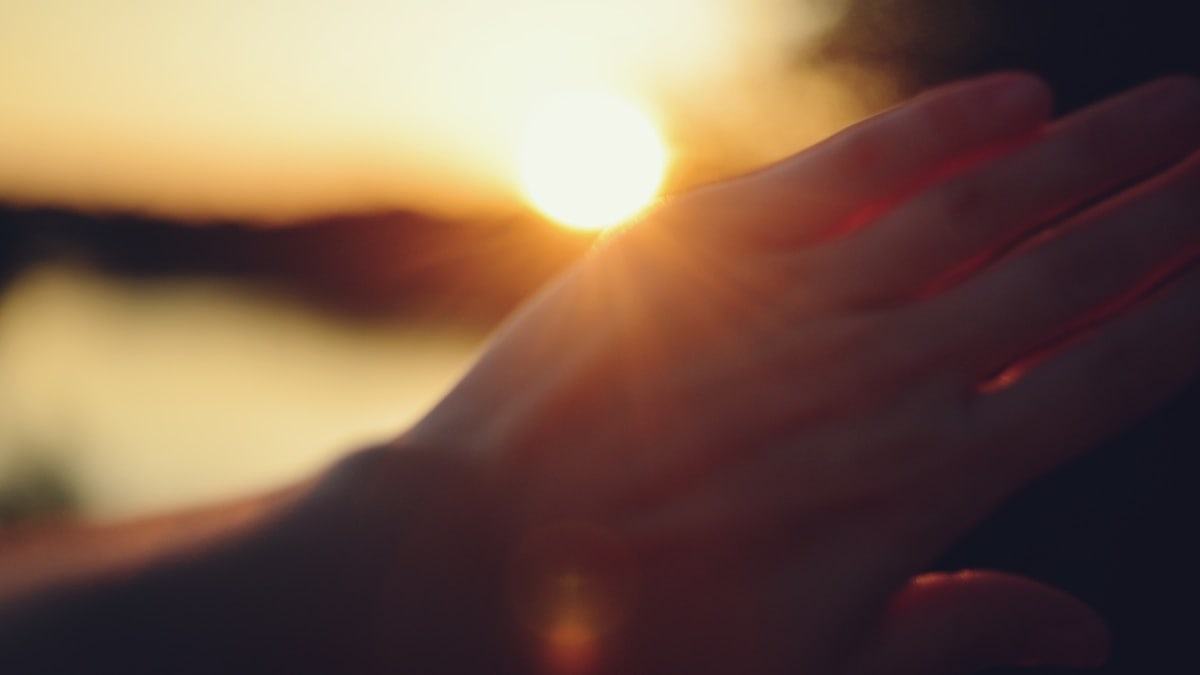 Hand shielding eyes from the setting sun